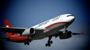 A large passenger jet flying through a blue sky