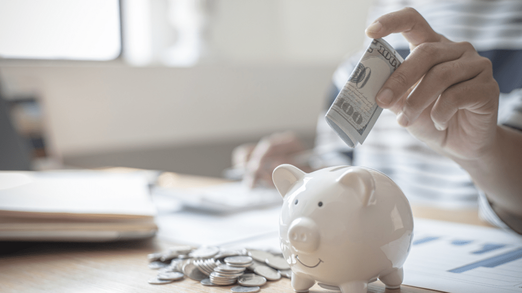 A person putting money into a piggy bank