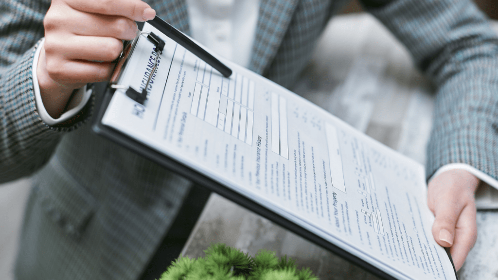 A person in a business suit is holding a clipboard