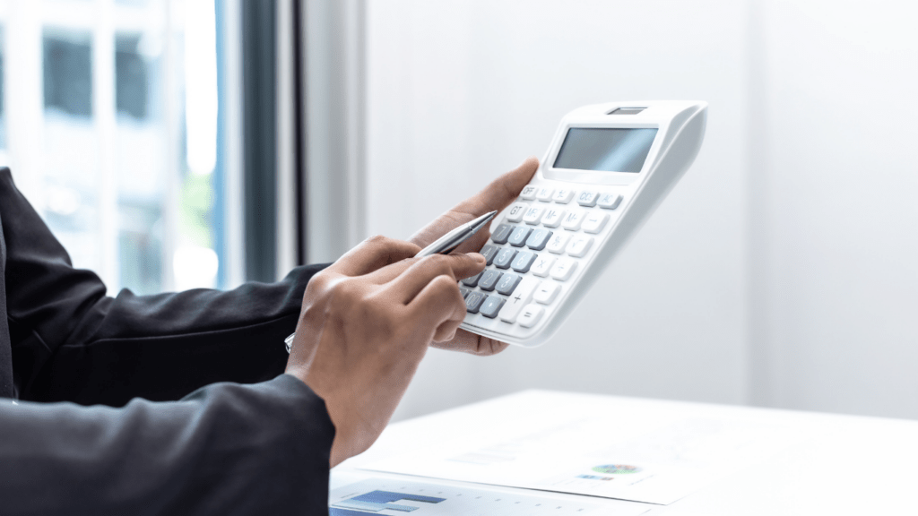 A person in a business suit is using a calculator