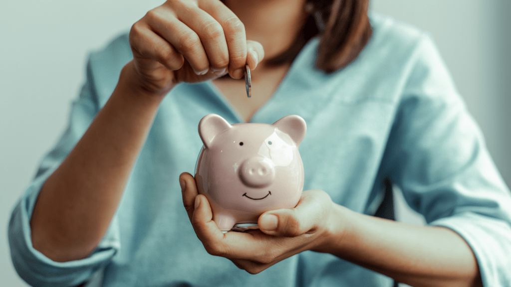 A person putting money into a piggy bank