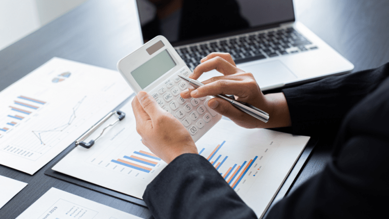 A person in a business suit is using a calculator