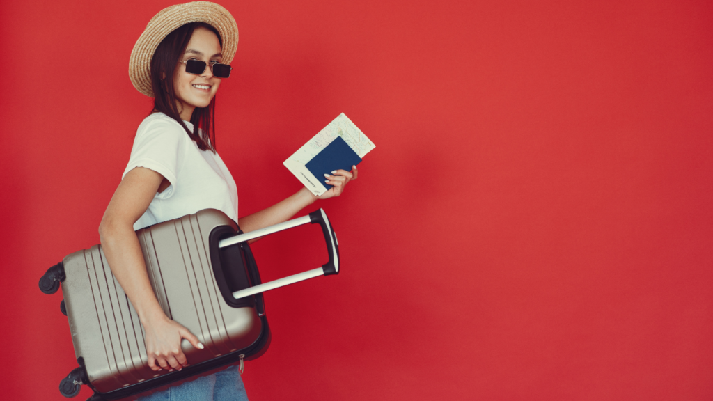 Female traveler with a suitcase on a red background