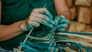 close up of hands making a woven bag