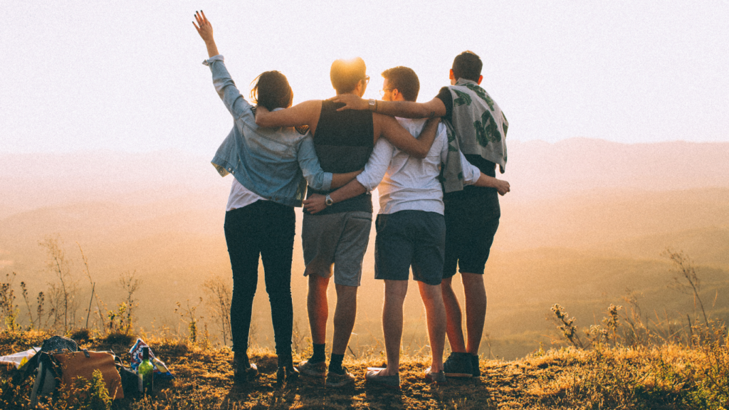 Friends standing together at sunset in the mountains