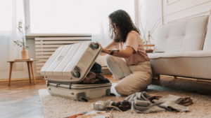 A person sitting on the floor with a suitcase full of clothes