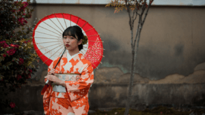 a person in an orange kimono holding an umbrella