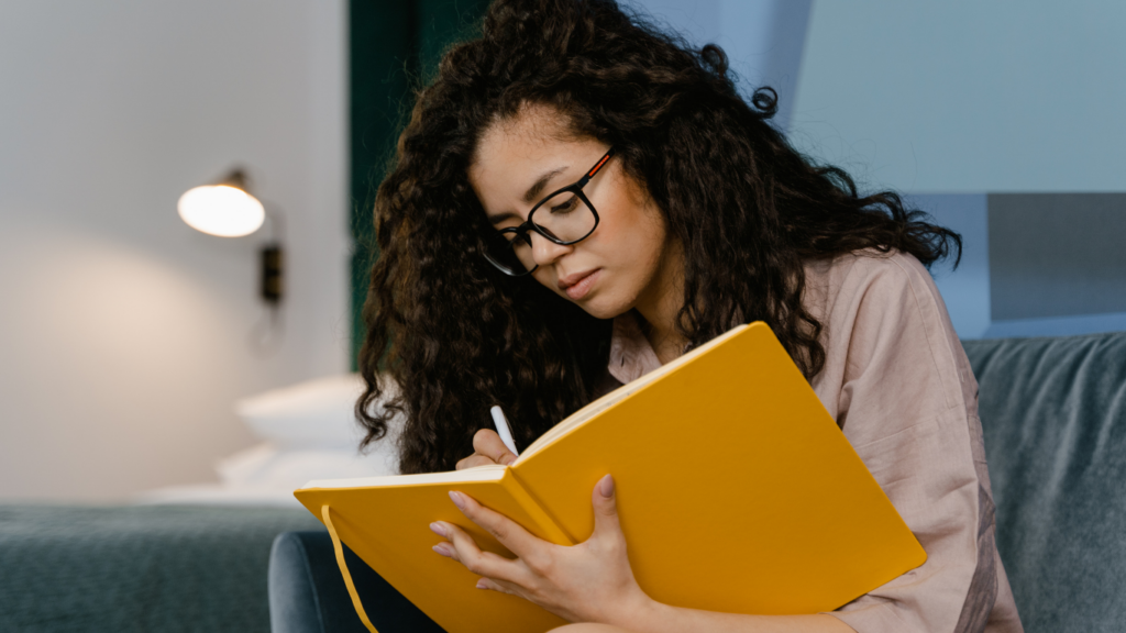 a person is writing in a notebook with a pen