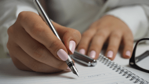 weekly planner with pen and cup of coffee on wooden table
