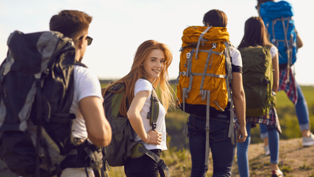a group of people with backpacks hiking up a mountain