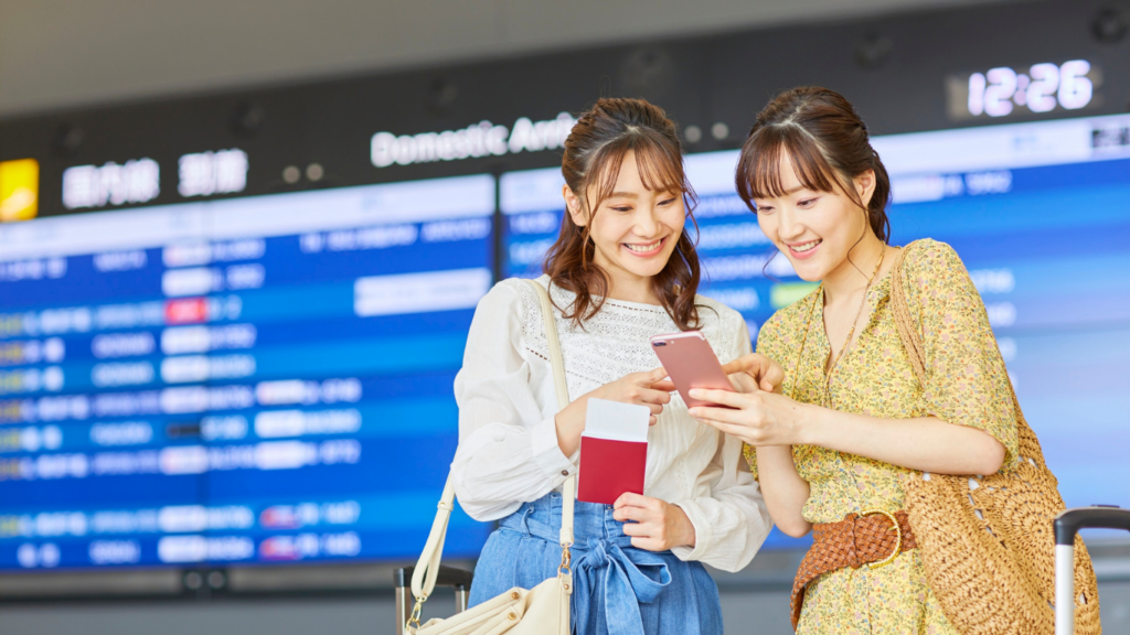 Girls checking their travel plans at an airport