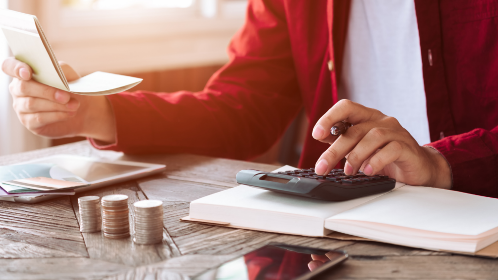 businessman using calculator and pen to write on paper