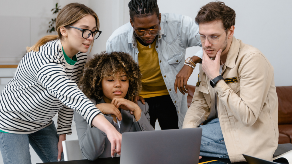 a group of people looking at a laptop