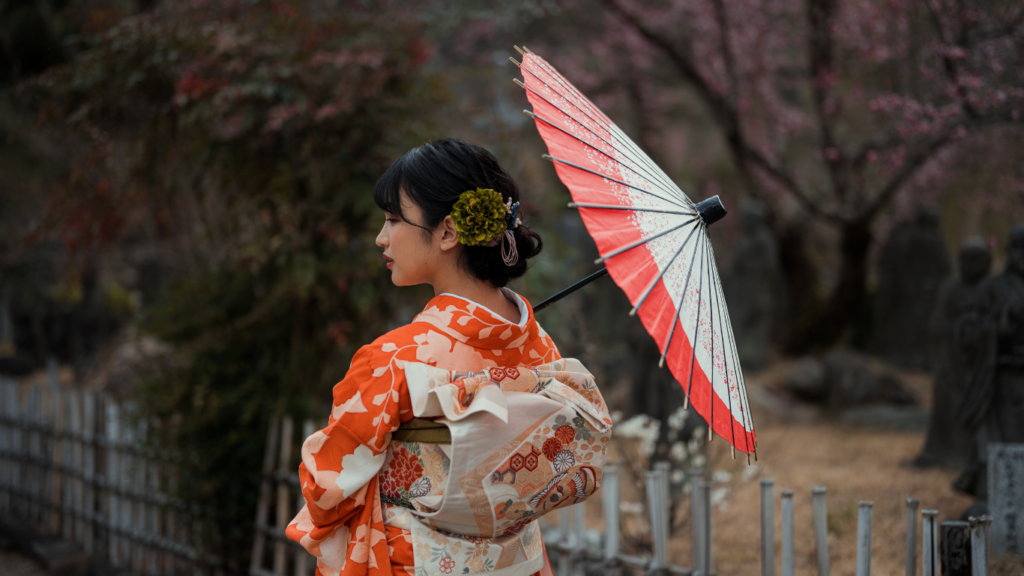 a person in an orange kimono holding an umbrella