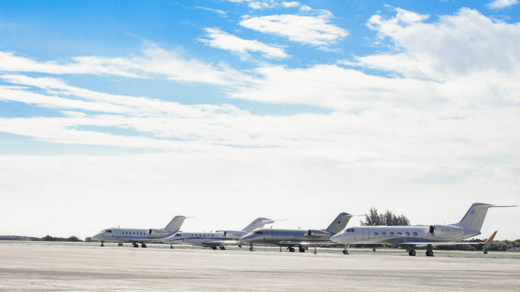 a row of private jets parked on an airport