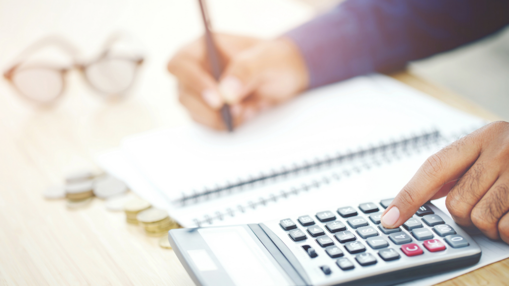 businessman using calculator and pen to write on paper