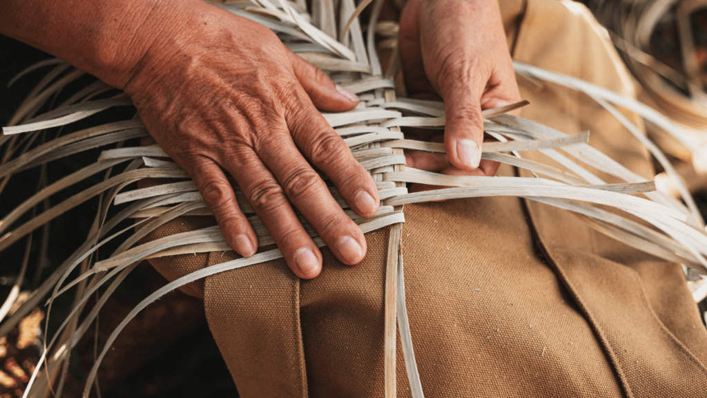 close up of hands making a woven bag