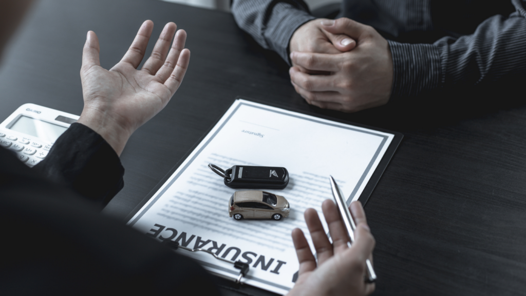 people sitting at a table with an insurance document
