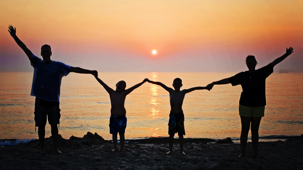 silhouette of a family on the beach at sunset